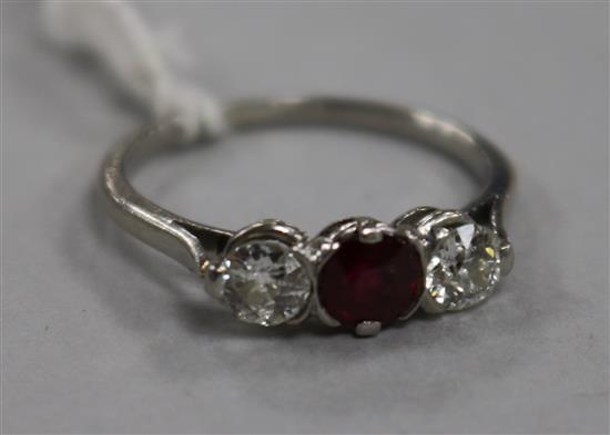 A white metal, ruby and diamond three stone ring, size M/N.